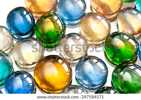 Glass balls marbles abstract colored mix on white background, color beads with window light reflections, colorful abstract in horizontal orientation, nobody.