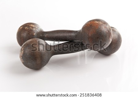 Old steel dumbbells weights black objects on white background in horizontal orientation, nobody.