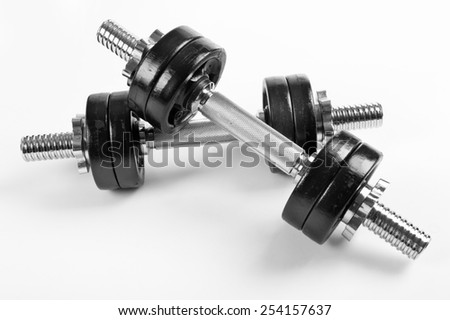 Two heavy hand barbells weights black color on white background in horizontal orientation, nobody.