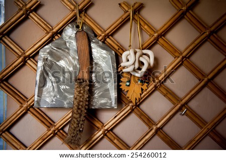 Old retro broom and dustpan hang on wall, domestic decorative accessories in horizontal orientation, nobody.