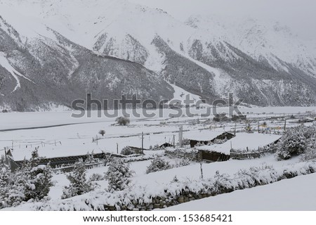 snow covered village - a Tibetan village is covered by snow close to Ranwu Lake is shown in circa Apr. 2012 to show its beauty and silence.