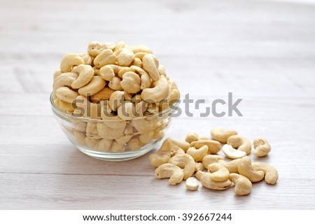 Cashew nuts in the glass bowl on wood table