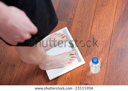 Healthy person weighing his weight on a balance