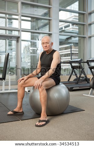 Man on balance ball in gym