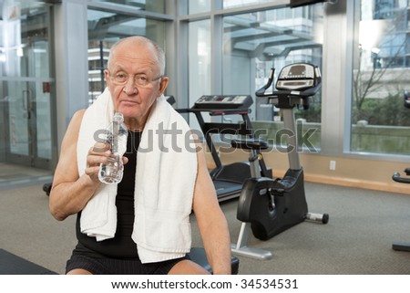Man in gym with towel drinking