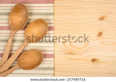wooden spoon and dish cloth on wooden table
