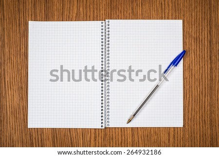 spiral notebook and pen on wooden desk