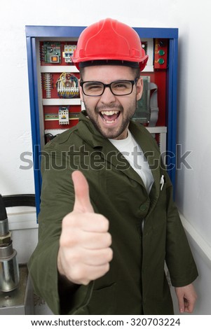young adult electrician builder engineer worker in front of fuse switch board