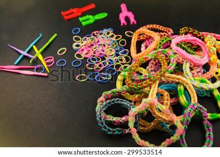Bright bracelets with elastic rubber on black background.