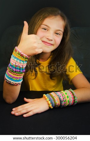 Young girl with bright rubber bracelets from wrists.
