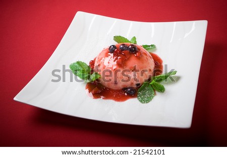 Close-up delicious summer pudding with some red fruits and mint leafs on red background