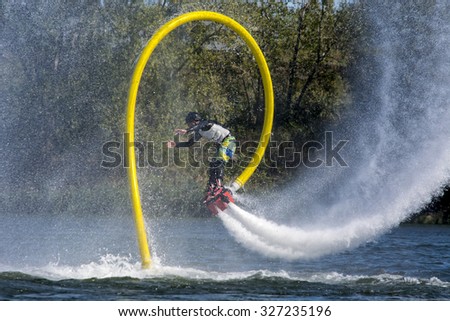 a man on a fly board is doing spectacular acrobatics on the St-Lawrence river in Verdun Quebec, picture taken on 24th of september 2015