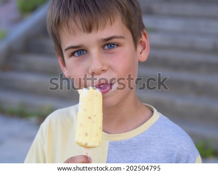 cute boy with blue eyes enjoying ice cream