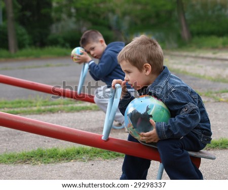 No play, no game. Two brothers sitting in the park, each with own ball