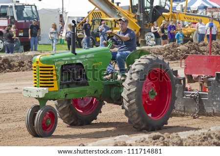 DE PERE, WI - AUGUST 18: A Oliver Super 77 Green & Red Tractor pulling the track weights at the Tractor Pull event at the Brown County Fair on August 18, 2012 in De Pere, Wisconsin.