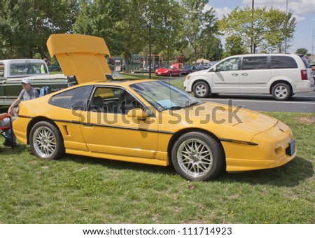COMBINED LOCKS, WI - AUGUST 18: Side view of a 1987 yellow Pontiac Fiero classic car at the 2nd Annual Horizon of Hope Generations Car and Truck Show on August 18, 2012 in Combined Locks, Wisconsin.