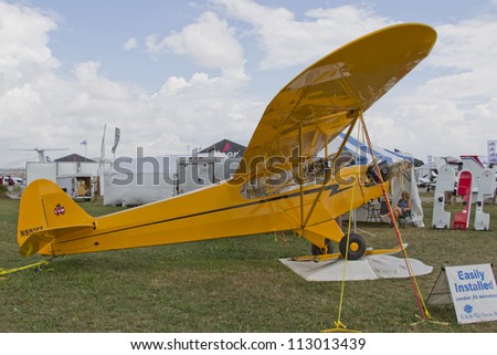 OSHKOSH, WI - JULY 27: Yellow Piper Cub Plane ready for Alaska on display with snowshoe and furs at the 2012 AirVenture at EAA on July 27, 2012 in Oshkosh, Wisconsin.
