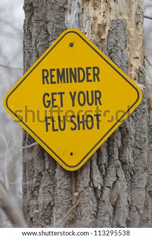 Reminder Get Your Flu Shot Sign on a tree making a great flu shot concept.