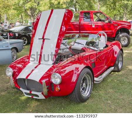 WAUPACA, WI - AUGUST 25: 1965 Red White Ford AC Cobra car at the 10th Annual Waupaca Rod & Classic Car Club Car Show on August 25, 2012 in Waupaca, Wisconsin.