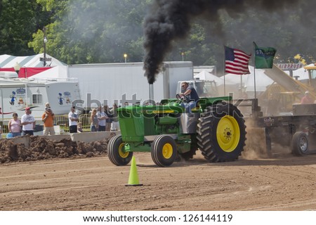 DE PERE, WI - AUGUST 18: Black smoke on a fast John Deere 6030 tractor competing at the Tractor Pull event at the Brown County Fair on August 18, 2012 in De Pere, Wisconsin.