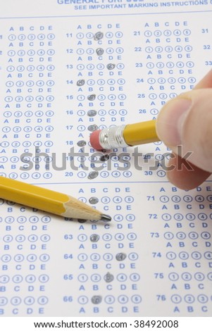 Blue, bubble test form completed for an exam  with a man erasing the answer circle with a number 2 pencil.