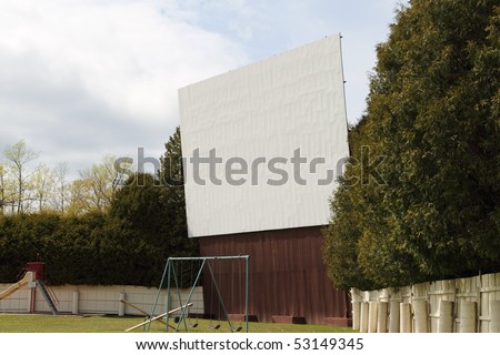 A vintage drive in movie theater screen and lot.