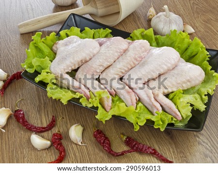 fresh chicken legs and spices on wooden table