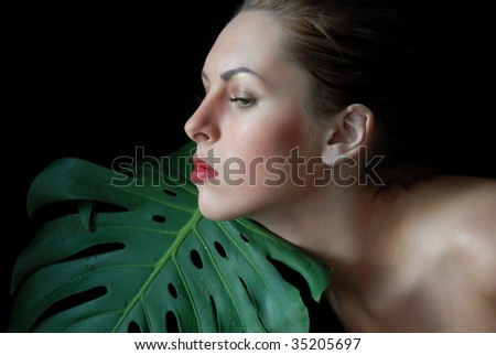 close up female profile and the big sheet of a plant.