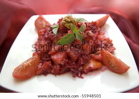 Bright red salad with fresh raw tomatoes, beets, walnuts, basil and lemon juice