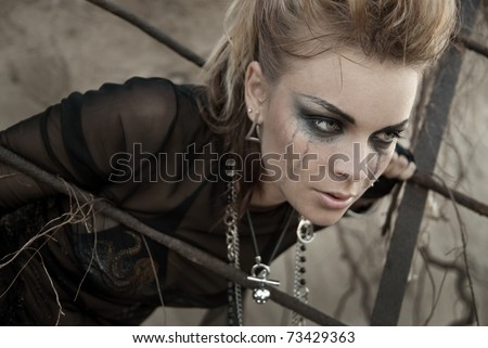 The girl dressed and make-up in rock style. Make-up after tears. She is upset and thoughtful, does not know what to do.