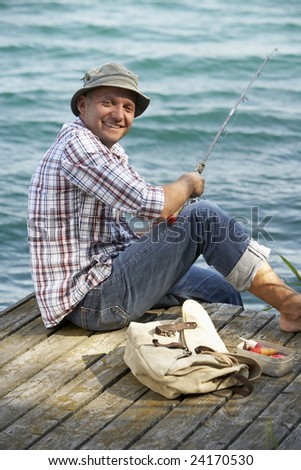 man fishing from a wooden pier