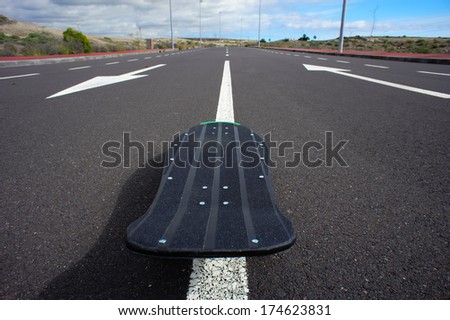 Vintage Style Longboard Black Skateboard on an Empty Asphalt Desert Road
