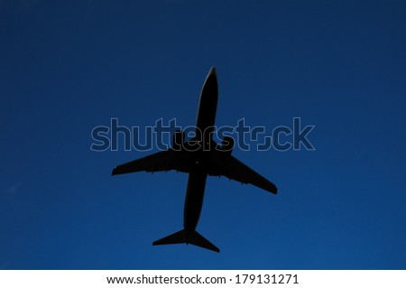Silhouette of an Airplane Landing into a evening sky