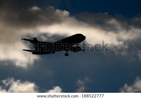 Silhouette of an Airplane Landing over a evening sky