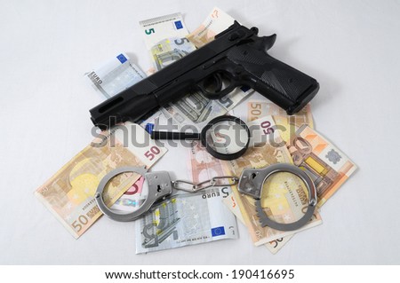 Financial Concept Handcuffs, Gun and Money on a White Background