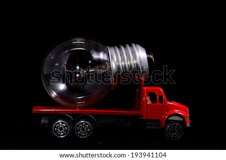 Electric Power Concept Red Truck and Light Bulb on a Black Background