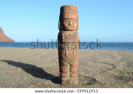 Ancient Maya Statue on the Sand Beach near the Ocean