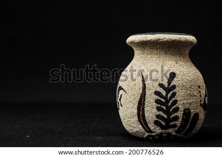 Colorful designed clay vase over a Black background