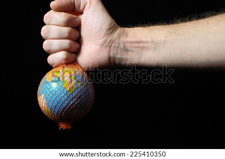 Trapped Planet Earth and an Hand on a Black Background