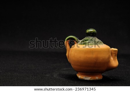 Colorful designed clay vase over a Black background