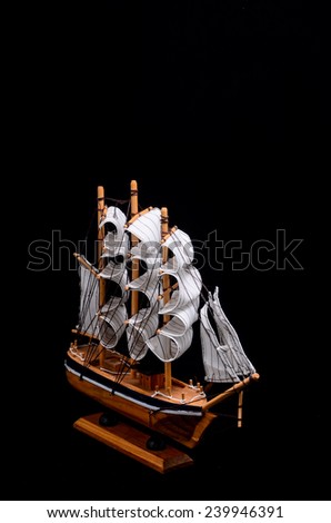 Ship Sailboat Wooden Model Figurine on a Black Background