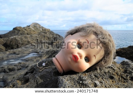 One Ancient Doll\'s Head Abandoned on the Rocks