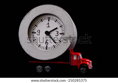 Time Transportation Concept Clock Watch on a Red Toy Truck over Black Background