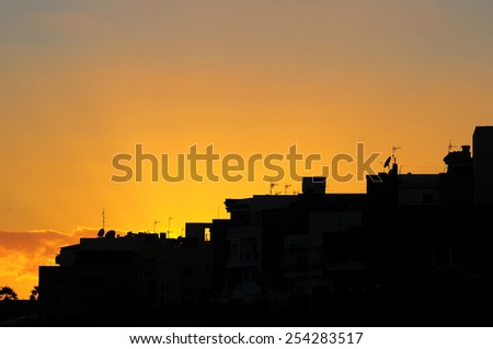 Silhouettes of Houses at Sunset over a Sea Village