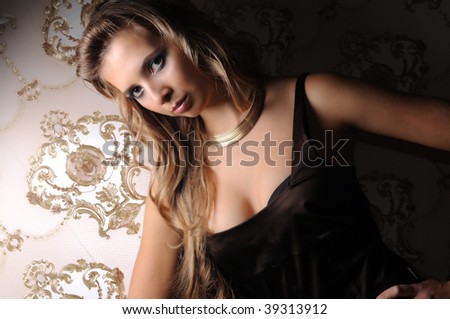 Portrait of beautiful sexy and hot girl on old style luxurious wallpaper