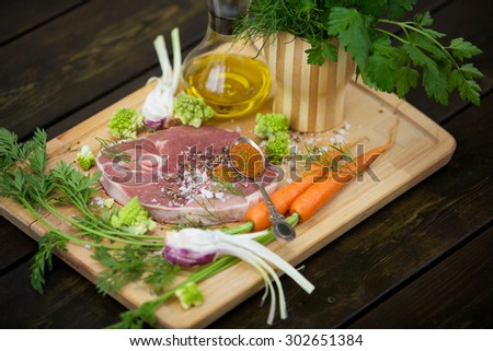 Fresh lamb steak with garlic, herbs, olive oil and garden vegetables