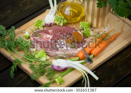 Fresh lamb steak with garlic, herbs, olive oil and garden vegetables