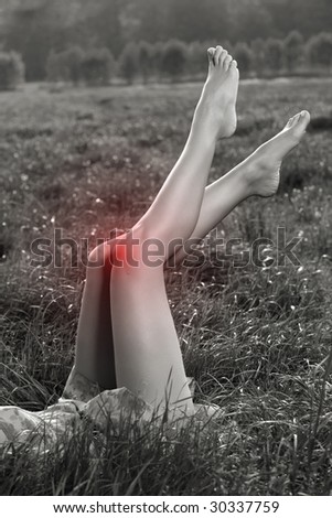 Pain in knee. Painful kneecap. Black and white photo with red area which shows the pain.