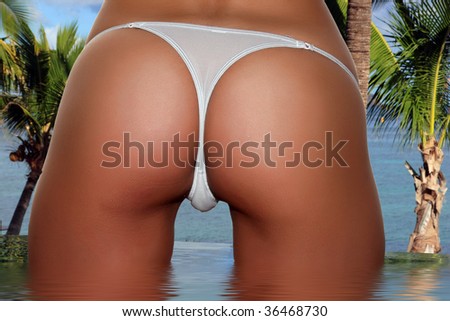 stock photo Beautiful skinny well tanned bottom with a white panty string 