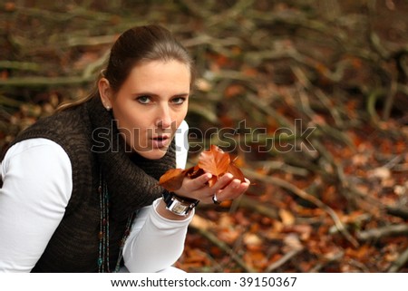 Attractive pretty woman portrait in autumn. In the USA it is called The Fall. This cute female outdoor photo was made in the forest